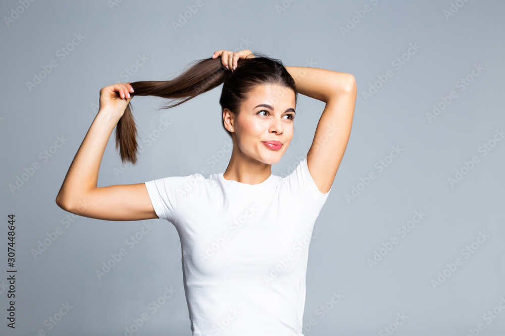 Young woman touching and play with her hair isolated on white background Young woman touching and play with her hair isolated on white background