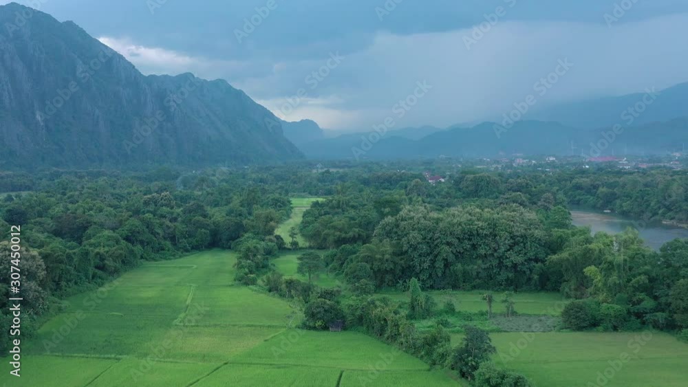Aerial view of village Vang Vieng and Nam Song rive , Laos. Southeast Asia. Photo made by drone from above. Bird eye view.. Aerial view of village Vang Vieng and Nam Song rive , Laos. Southeast Asia. Photo made by drone from above. Bird eye view..