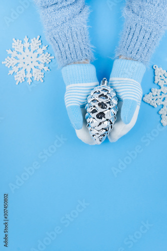 Fototapeta Naklejka Na Ścianę i Meble -  Children's hands in woolen mittens on a blue background. Winter concept. Christmas concept. Close-up copy space