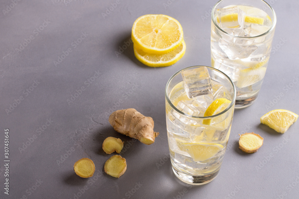 A glass of ginger water on grey table. Detox drink. A glass of ginger water on grey table. Detox drink.