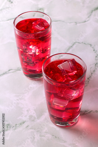 Obraz na plátně Glass of mango dragonfruit refresher drink on marble table with ice cubes
