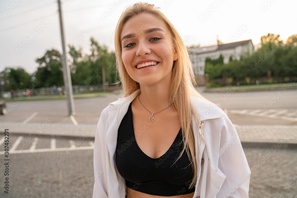 Close up portrait of the beautiful blonde girl with natural makeup that smiling and looking at the camera