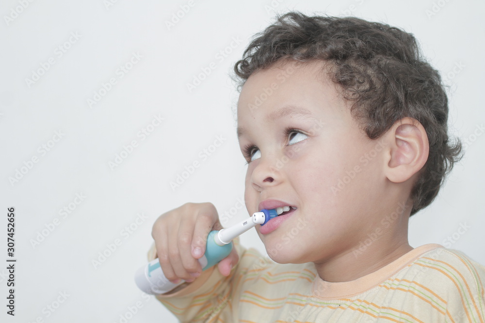 little boy brushing his teeth with an electric tooth brush stock image with grey background stock photo little boy brushing his teeth with an electric tooth brush stock image with grey background stock photo
