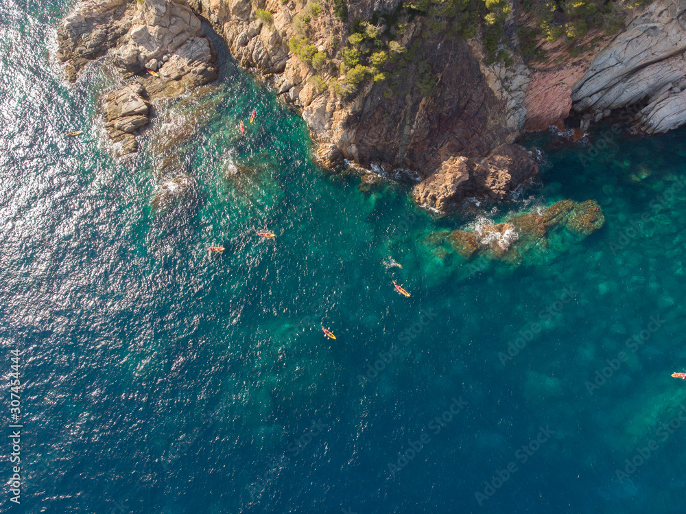 Aerial view of a group of kayakers paddling around the Mediterranean Aerial view of a group of kayakers paddling around the Mediterranean