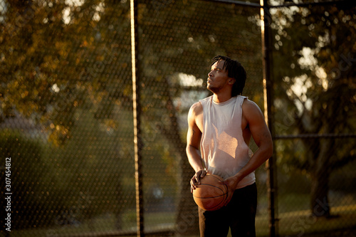 African-American man playing basketball outdoors photo