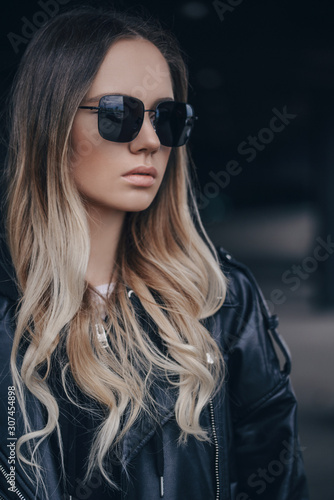 Portrait of beautiful blonde woman in black sunglasses in outdoor