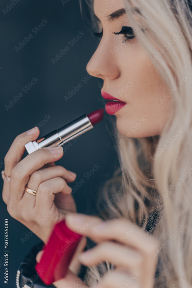 Portrait of young woman with beautiful makeup, holding red lipstick. Portrait of young woman with beautiful makeup, holding red lipstick.