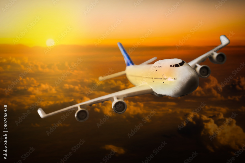 Fototapeta premium Airplane flying above clouds during sunset