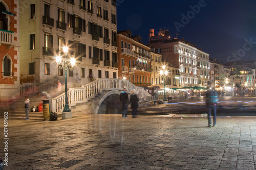 Long exposure of the Grand Canal of Venice with people on the sidewalk