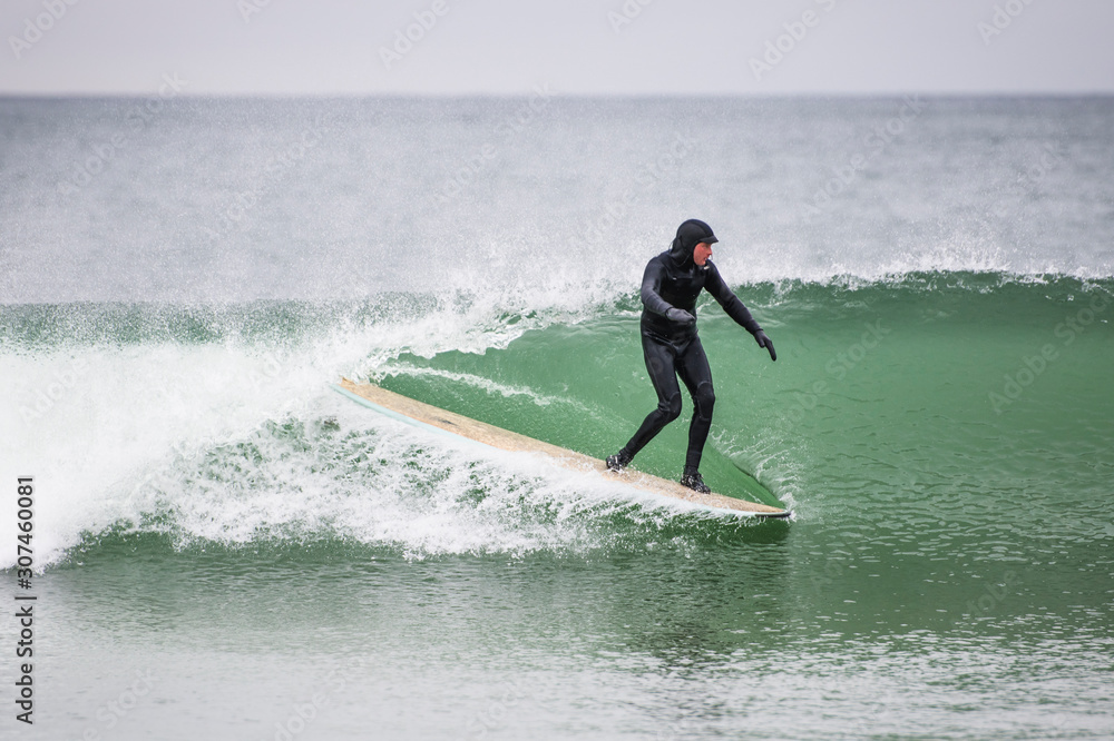 Man surfing wave on gray winter day Man surfing wave on gray winter day