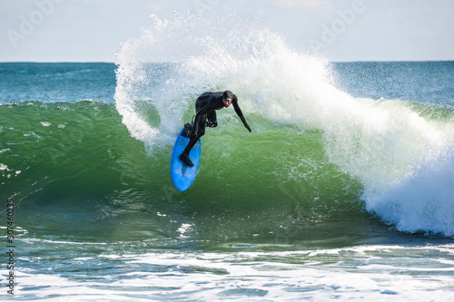 Man surfing sunny winter surf day with wind photo