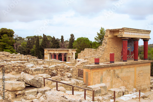 Knossos. Ruins of an ancient Minoan palace, stone walls and red columns. Crete, Greece.