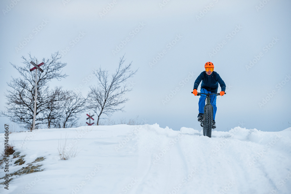 Man cycling in winter landscape Man cycling in winter landscape