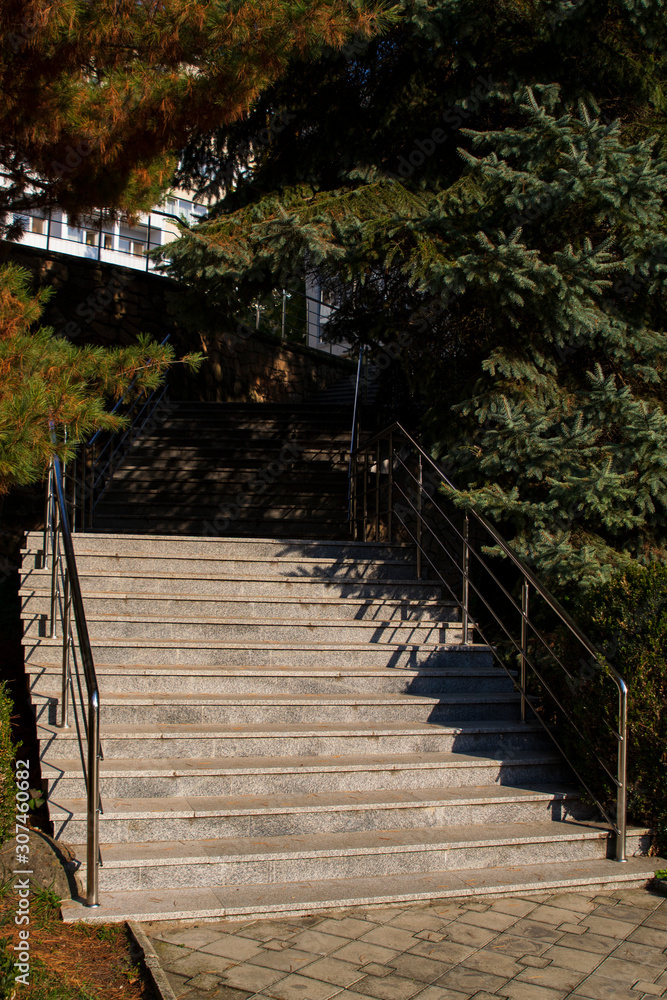 Obraz premium stone staircase, iron railing, Sunny day, shadows from trees