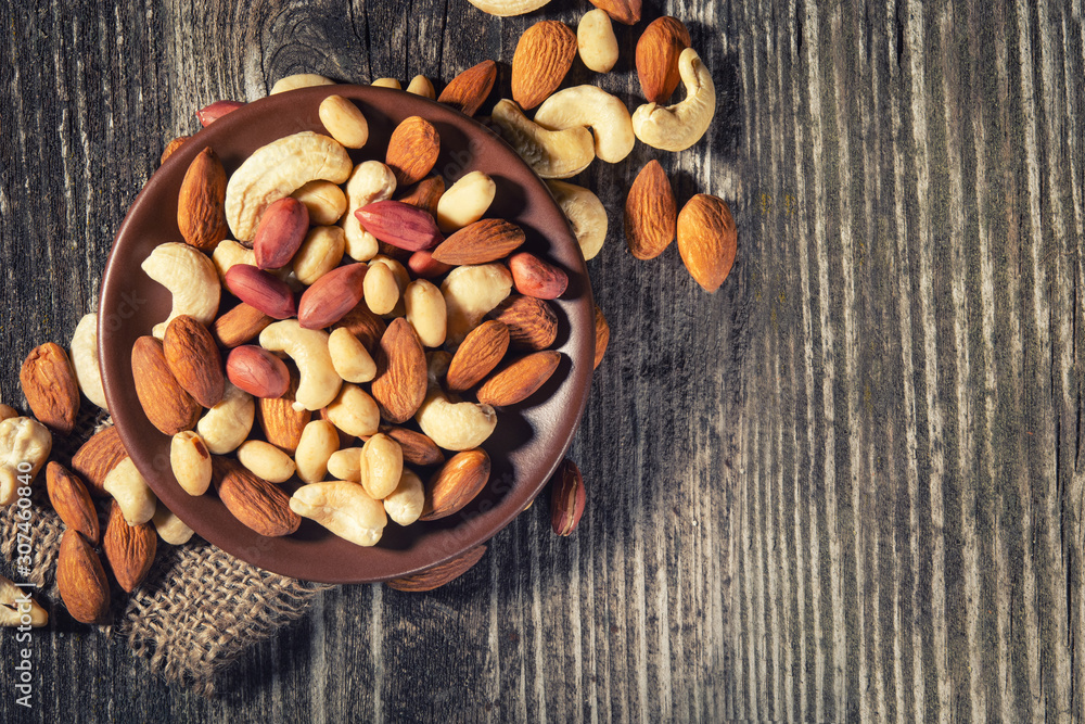 mixed nuts in a bowl on wooden table, top view with copy space mixed nuts in a bowl on wooden table, top view with copy space