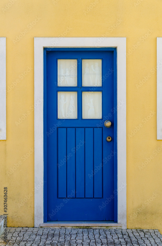 Beautiful blue gate with a yellow facade