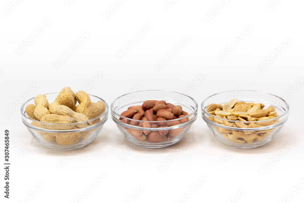 arachidi con guscio, pelle e senza all'interno di una ciotola di vetro su uno sfondo bianco