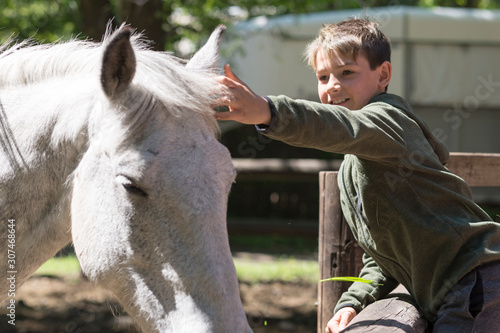 Niño con su mejor amigo, su caballo blanco.  photo