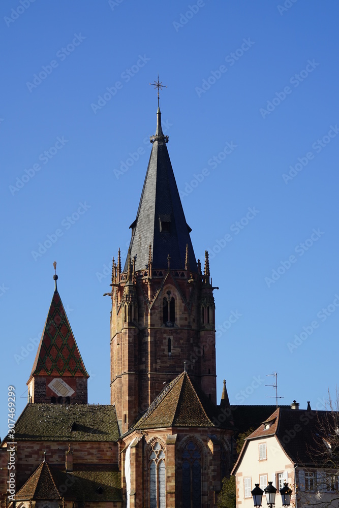 Die Kirche St. Peter und Paul in Wissembourg mit einem alten Haus