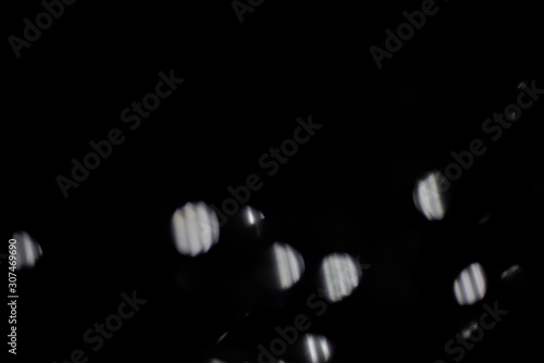 Blurred abstract black background with white lights.