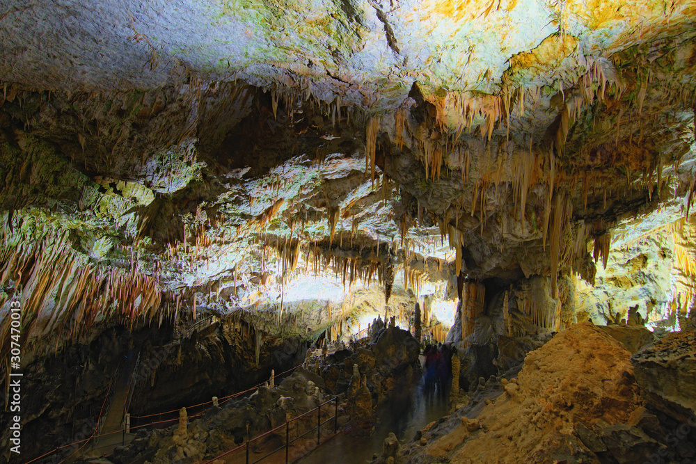 Scenic landscape view of Postojna Cave. Ancient formations inside cave with stalactites and stalagmites. Famous touristic place and travel destination in Europe. Slovenia