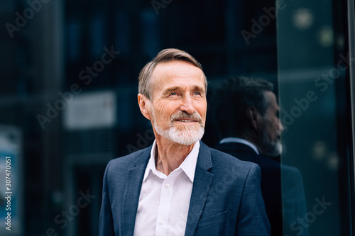 Bearded man wearing suit standing at office building outdoors