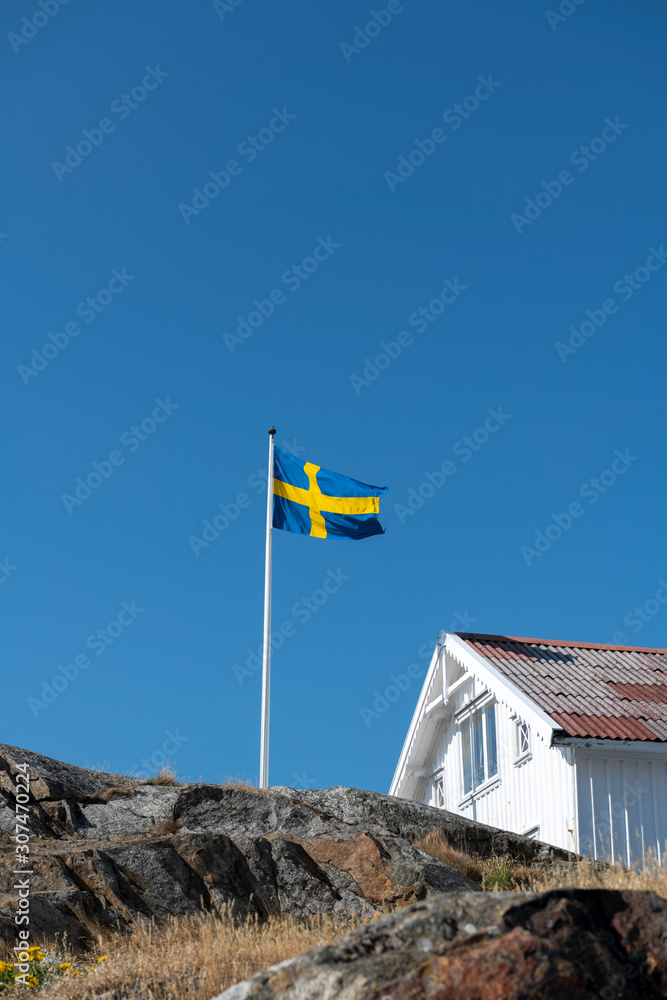 Swedish flag near wooden house