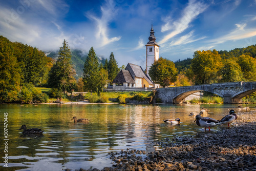 Scenic view of Lake Bohinj church with beautiful colorful foliage, Slovenia