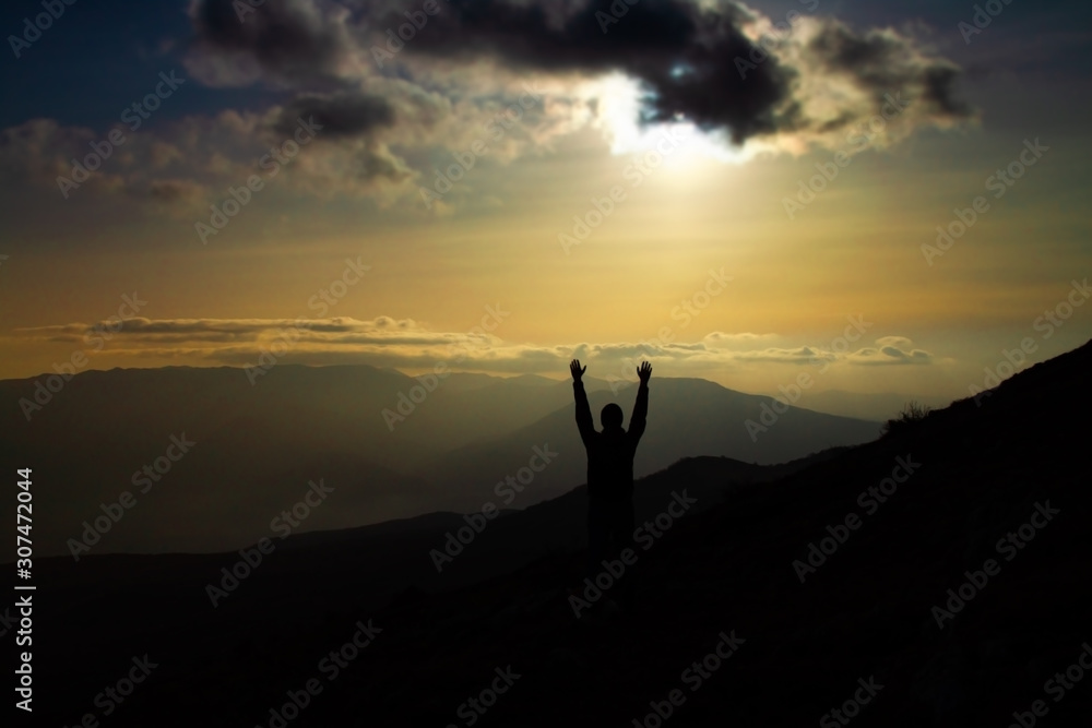 Man raised hands mountains on background. Young man traveling n the mountains. Travel Lifestyle concept.