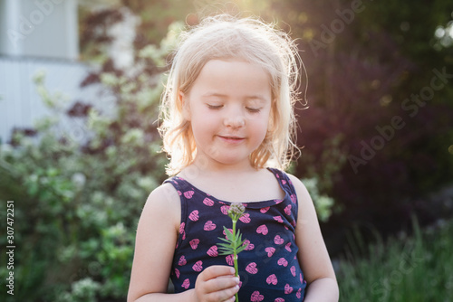 Girl holding small flower photo