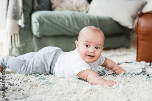 Baby boy lying on carpet photo