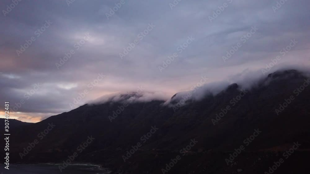 Slow pan from cloud-covered mountains to cape at Hout Bay, South Africa, at dusk Slow pan from cloud-covered mountains to cape at Hout Bay, South Africa, at dusk