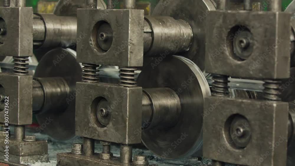 Industrial steel roll coil for metal profile forming machine in metalwork factory workshop. Close up. Industrial steel roll coil for metal profile forming machine in metalwork factory workshop. Close up.