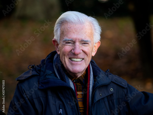 Senior man smiling looking at the camera in Hyde Park, London. Autumn