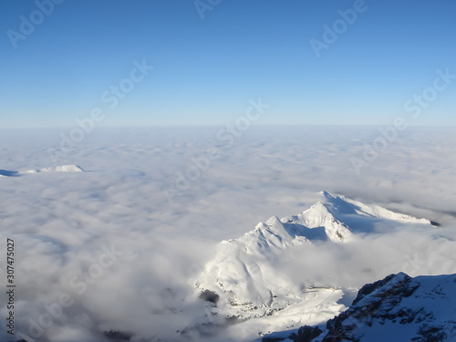 View over the clouds on the horizon line landscape, from the top of snow-capped mountains © Sergey