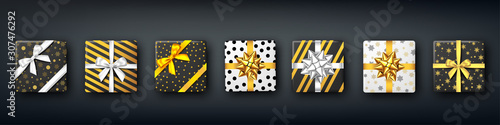 Christmas black gift box with silver and golden bow.