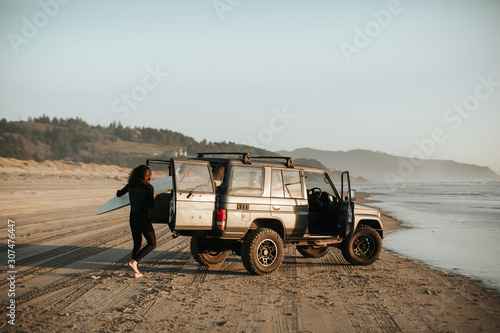 Man loading surfboard in 4x4 photo