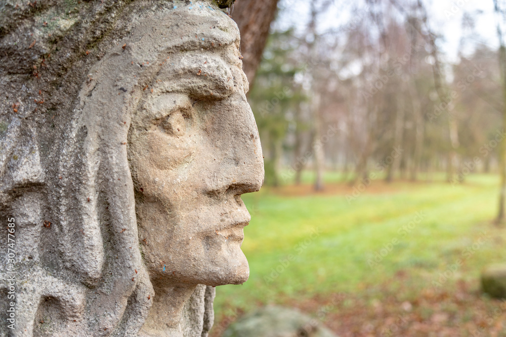 Vintage style native american face of the statue fragment with copy space forest background. Religiuos concept.