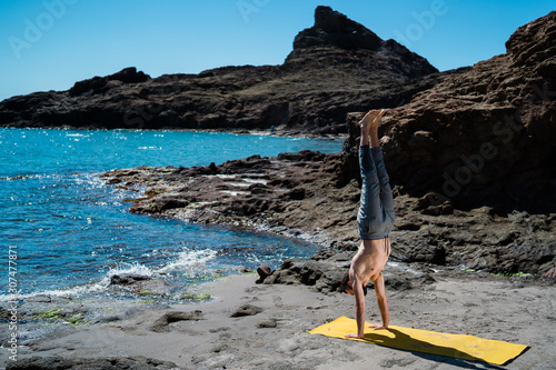 Caucasian Man doing a Yoga Practice on a natural beach