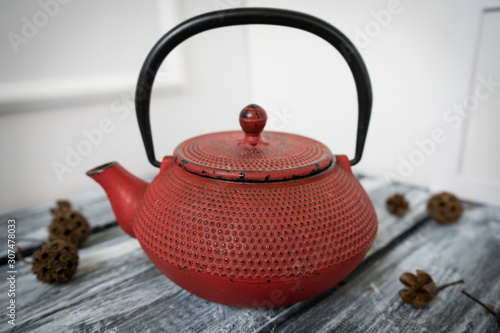 Red cast iron vintage teapot close up on vintage wood and brick surface