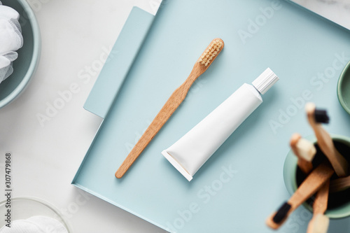 Natural toothbrush with paste tube on tray photo