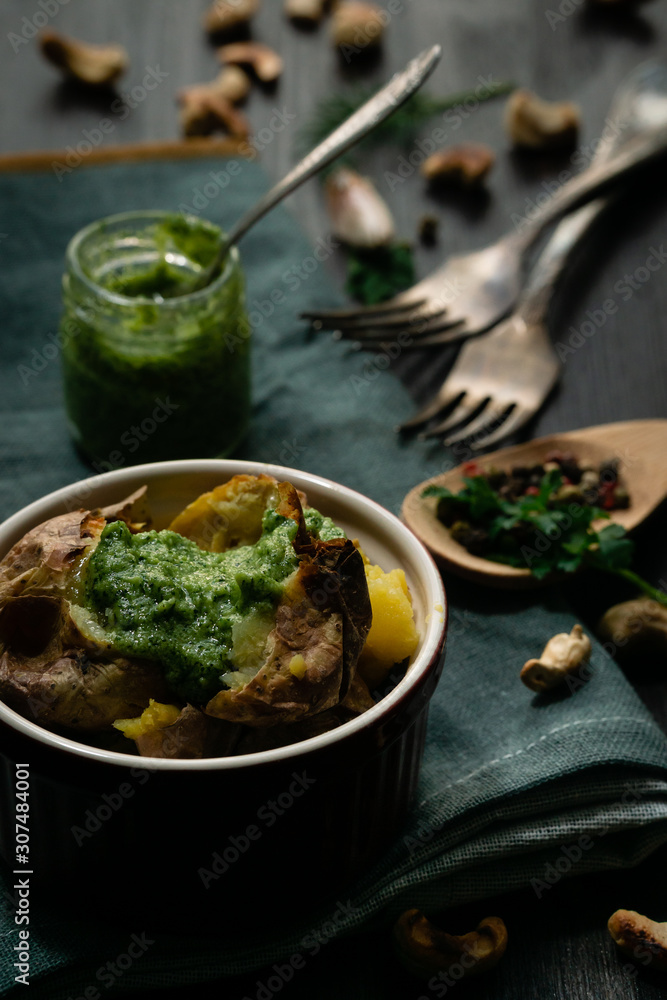 Baked potato with green pesto sauce with cheese Baked potato with green pesto sauce with cheese