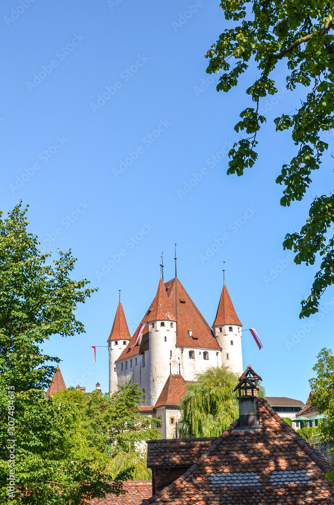 Historical Thun Castle in Thun, Switzerland photographed with the adjacent green trees. 12th-century Gothic-style castle is a Swiss heritage site of national significance. Tourist landmark