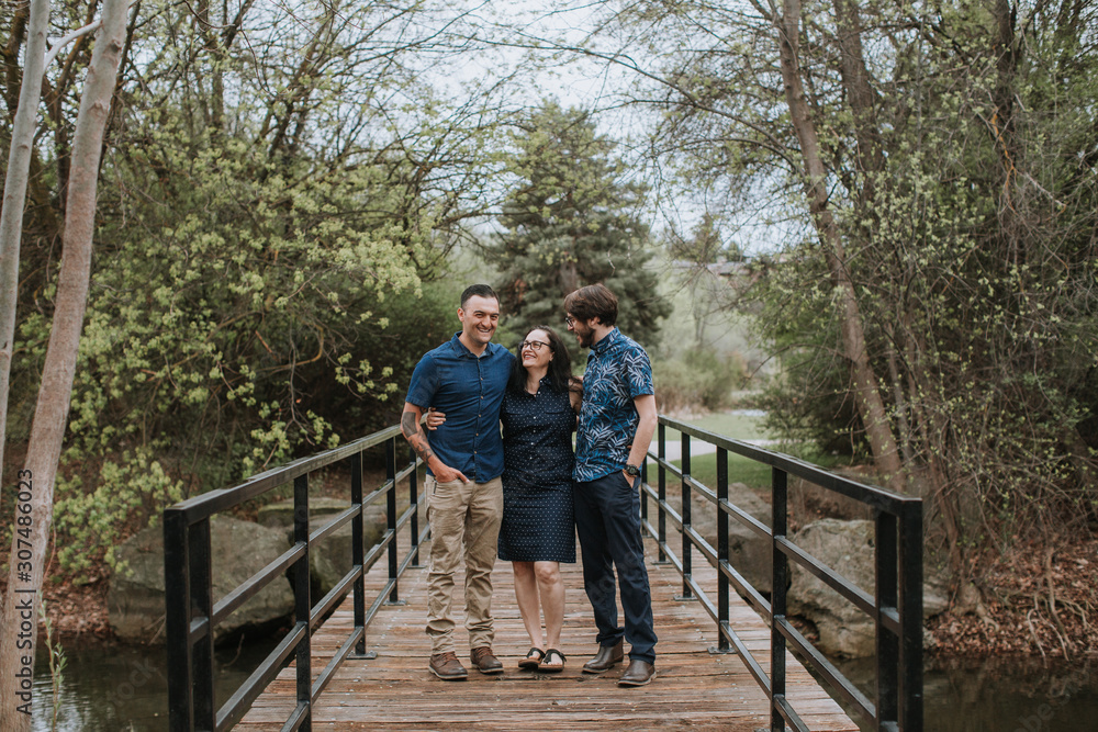 Happy Family Standing on Bridge in Park Happy Family Standing on Bridge in Park