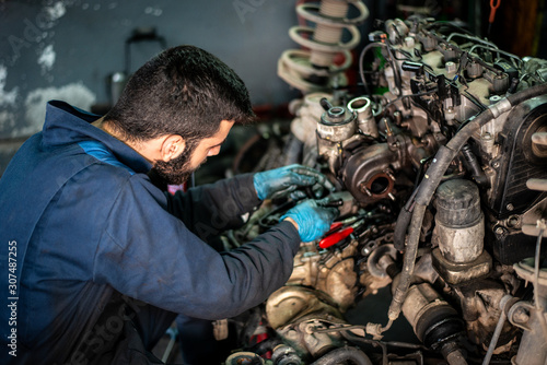 Car service and maintenance: an automechanic is repairing a vehicle © Addy