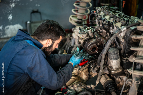 Car service and maintenance: an automechanic is repairing a vehicle