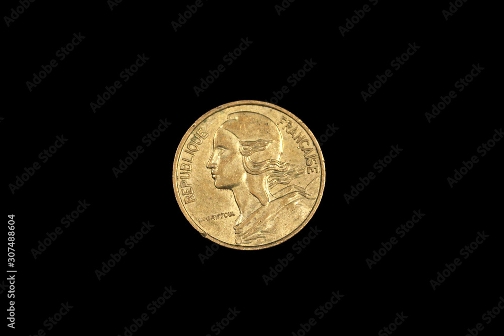 An old five French centimes coin, shot close up in macro, on a black background An old five French centimes coin, shot close up in macro, on a black background