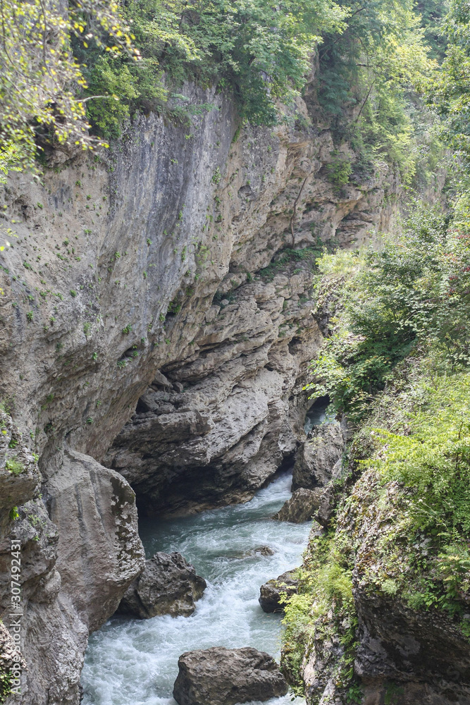 Pure and beautiful natural scenery of river White, Caucasus, Russia. The road goes up the mountain river. Canyon gorge, rocks, river and summer forest. 