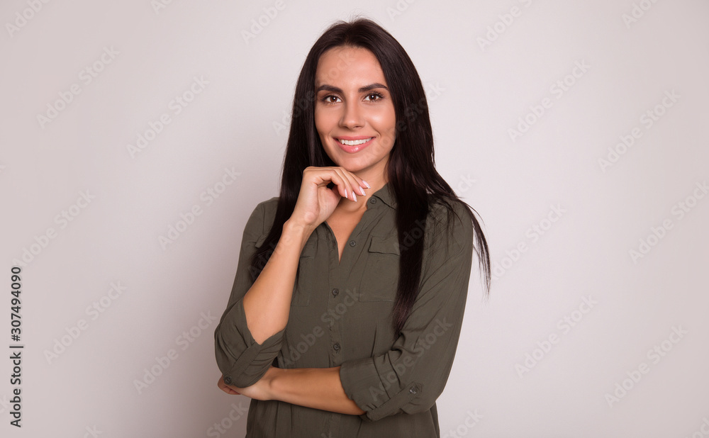 Perfect woman. Close-up photo of an attractive girl with long black hair, who is posing with her right hand near her chin and her left arm folded, smiling broadly and gazing in the camera. Perfect woman. Close-up photo of an attractive girl with long black hair, who is posing with her right hand near her chin and her left arm folded, smiling broadly and gazing in the camera.