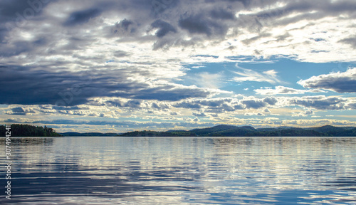 Beautiful sky and its reflection on the lake. Mirror summer lake. Ladoga Lake in Karelia. Russia